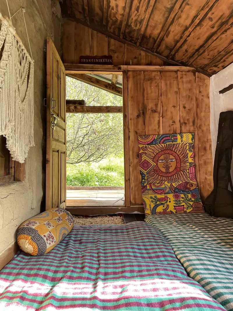 Shantiniketan Cafe — cozy interior with colorful pillows and wooden doors