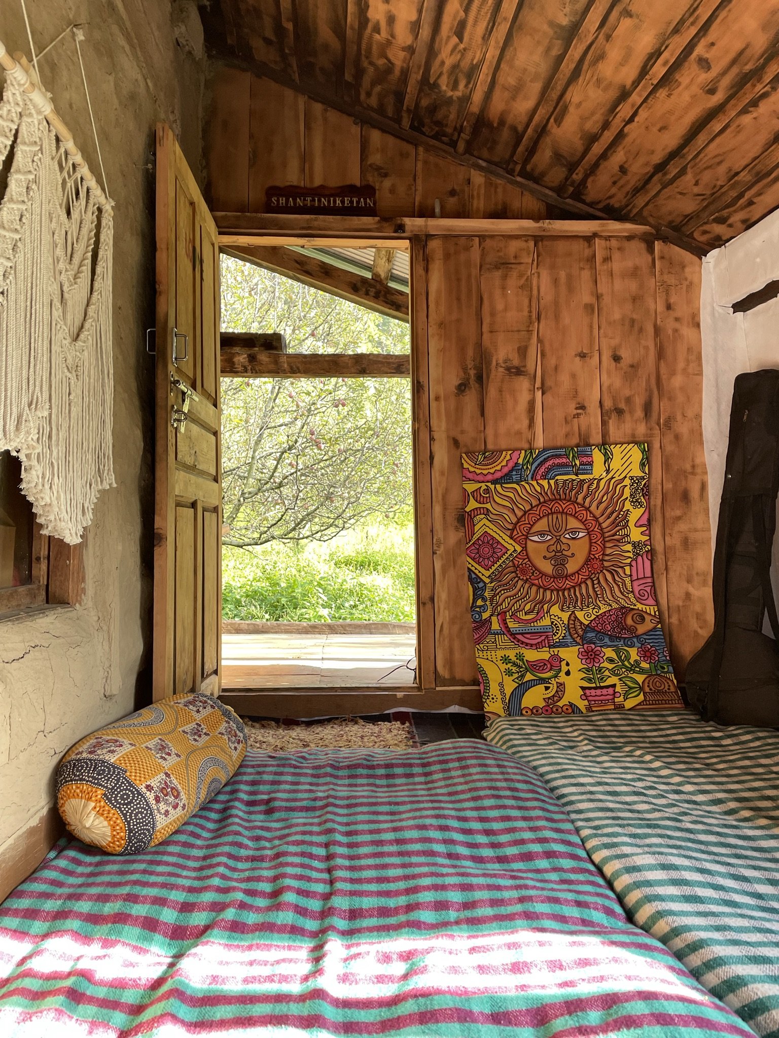 Shantiniketan Cafe — cozy interior with colorful pillows and wooden doors